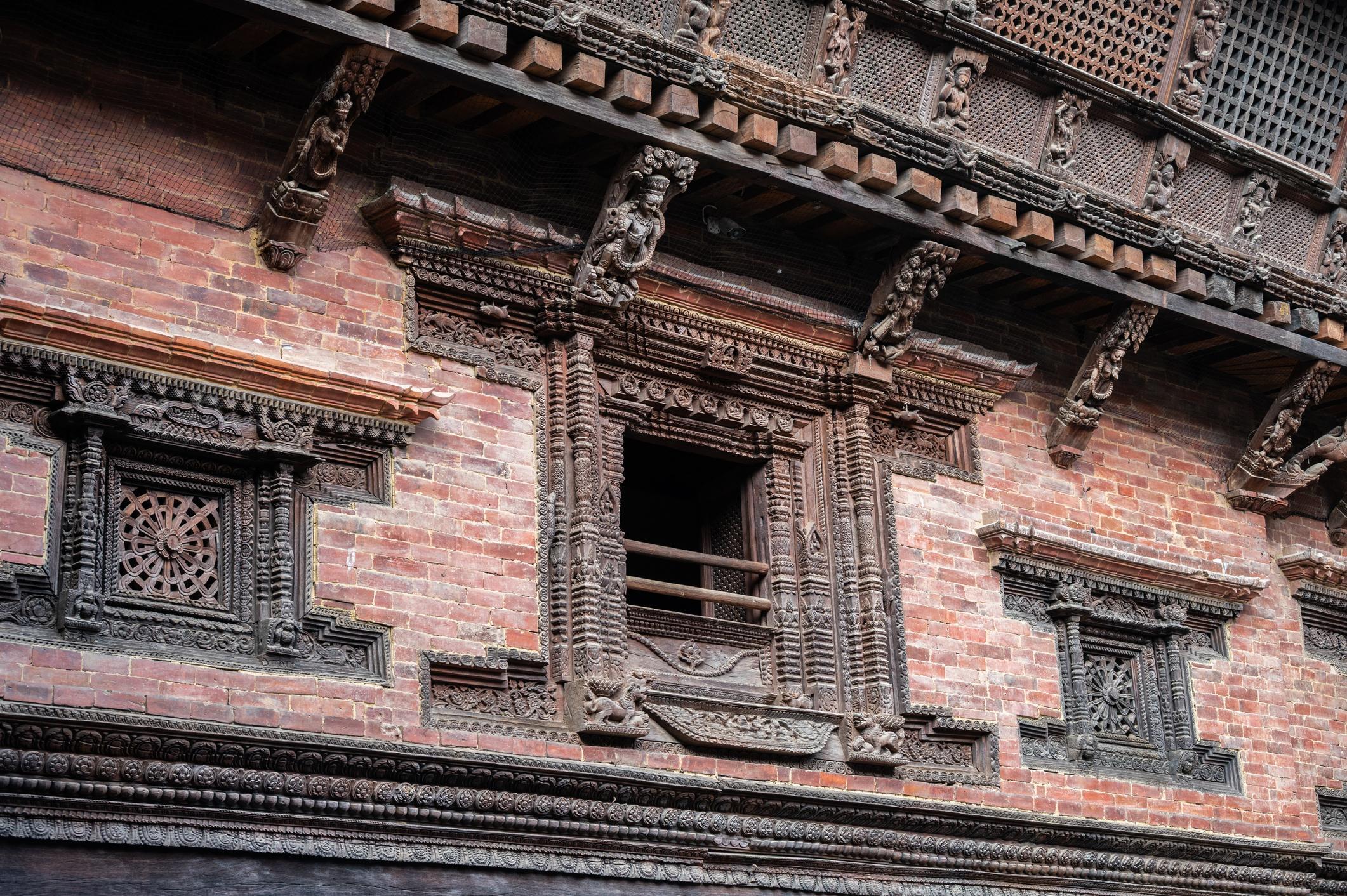 Intricately carved wooden windows in Bhaktapur reflecting classic Newar craftsmanship and historic architectural detail.