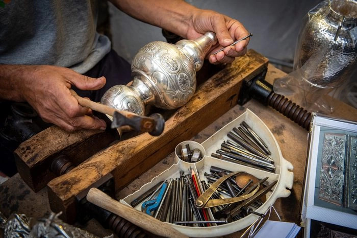 Traditional Newar metalwork being crafted by artisans in Bhaktapur reflecting centuries-old craftsmanship.